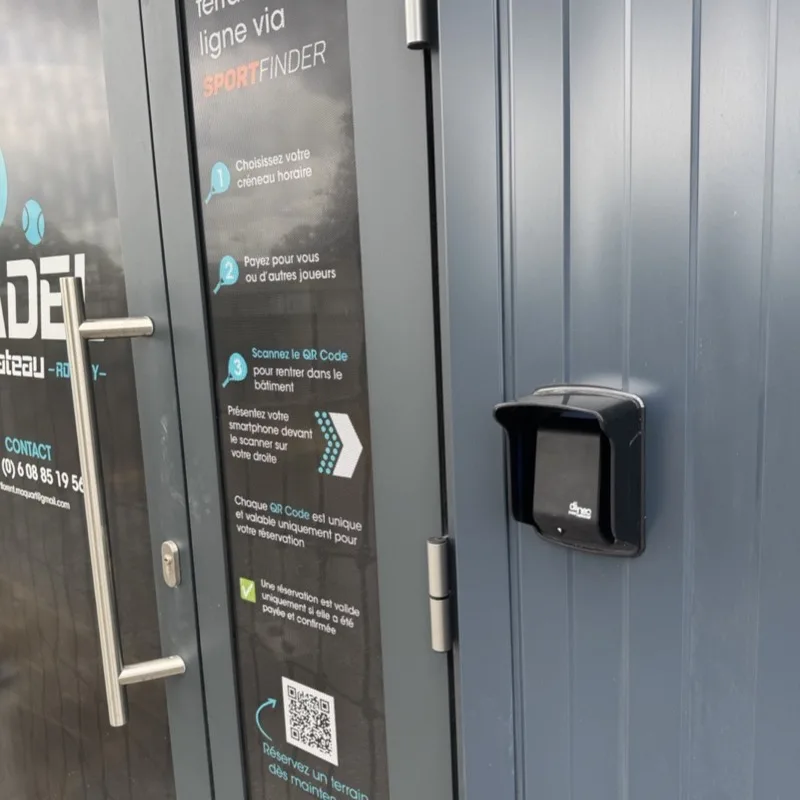 Sur la porte d'un club, le mode d'emploi du QR code d'accès en trois étapes, à côté du lecteur de la porte